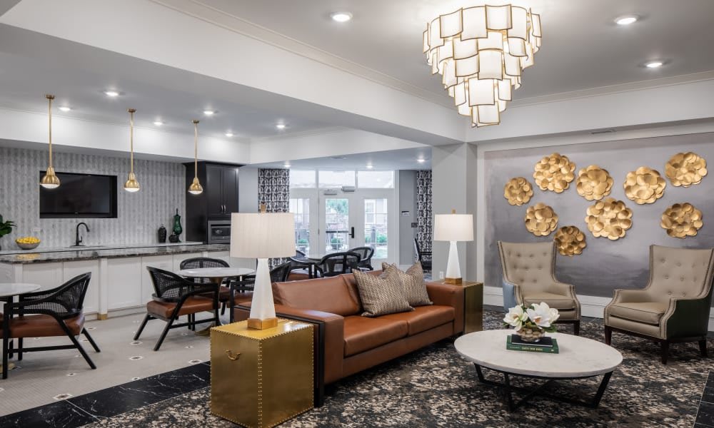 A modern living room with elegant decor and furniture, featuring a large chandelier and comfortable seating.