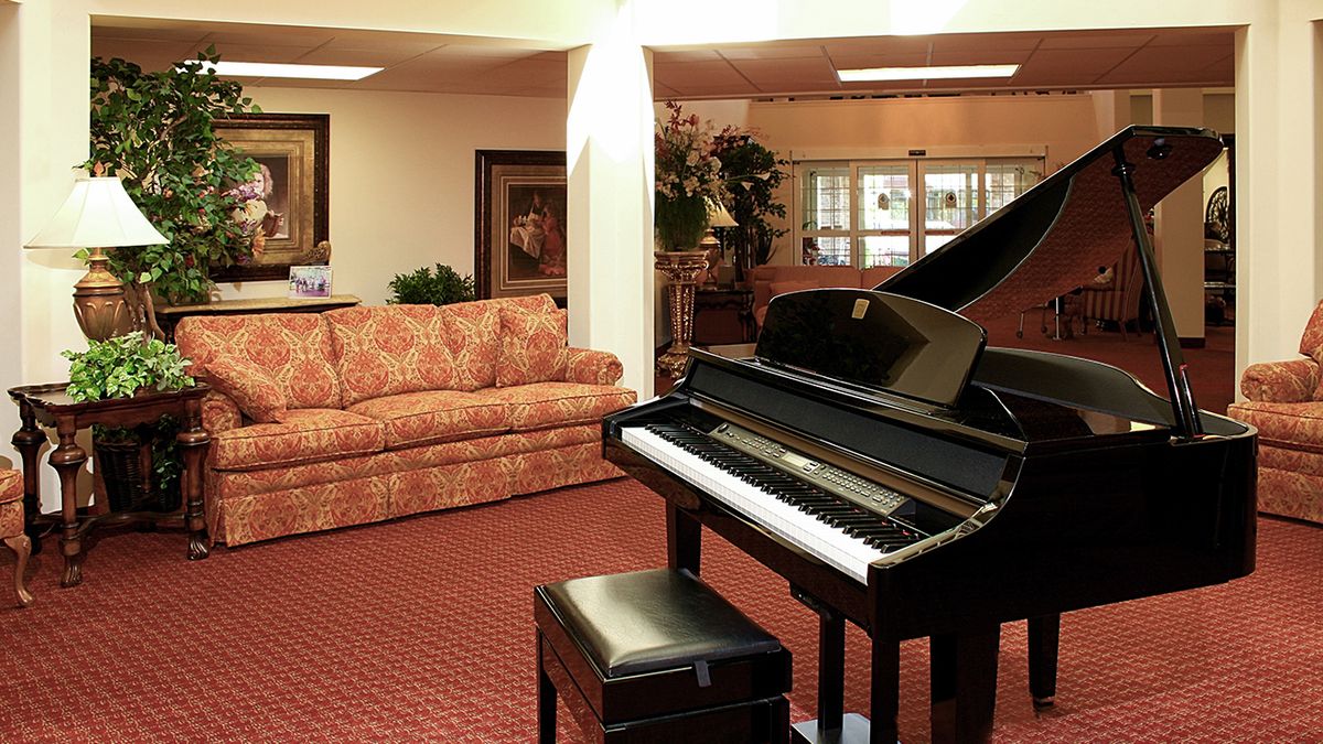 A cozy living room featuring a grand piano and a plush sofa.