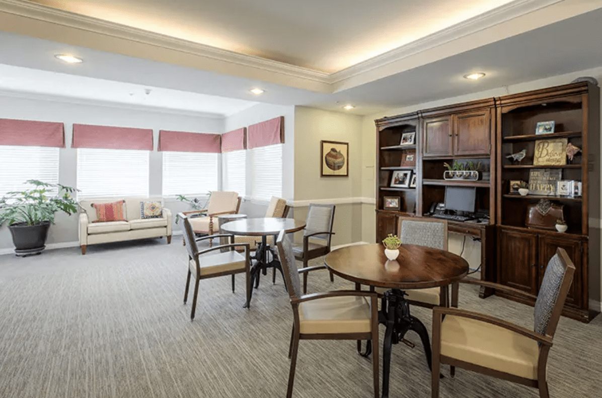 A cozy living area with multiple seating arrangements and a bookshelf.