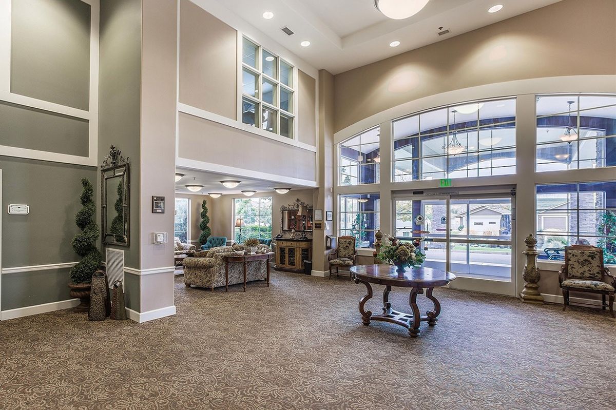 A spacious and elegantly decorated lobby with large windows and comfortable seating.