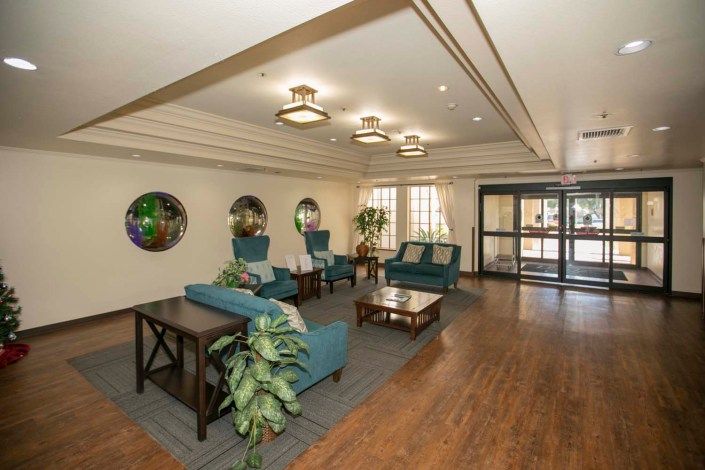 A spacious lobby area featuring comfortable seating, decorative plants, and modern lighting fixtures.