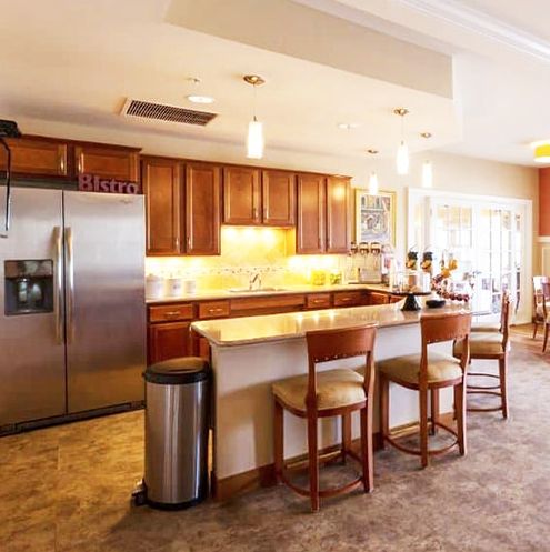 A modern kitchen with wooden cabinets, an island counter, and stainless steel appliances.