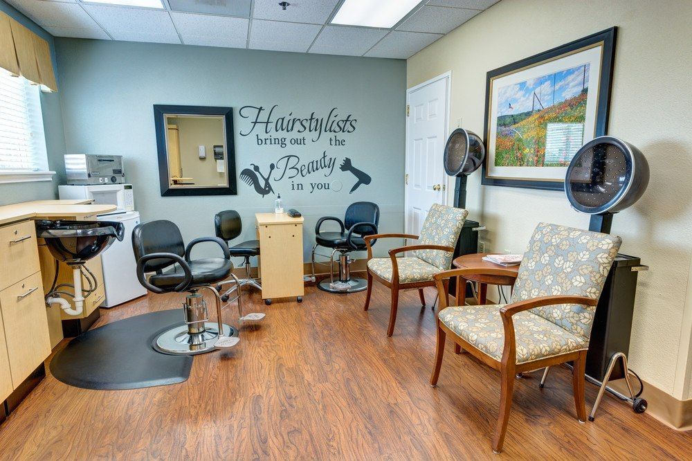 A cozy hair salon interior featuring a waiting area with chairs and hair styling stations.