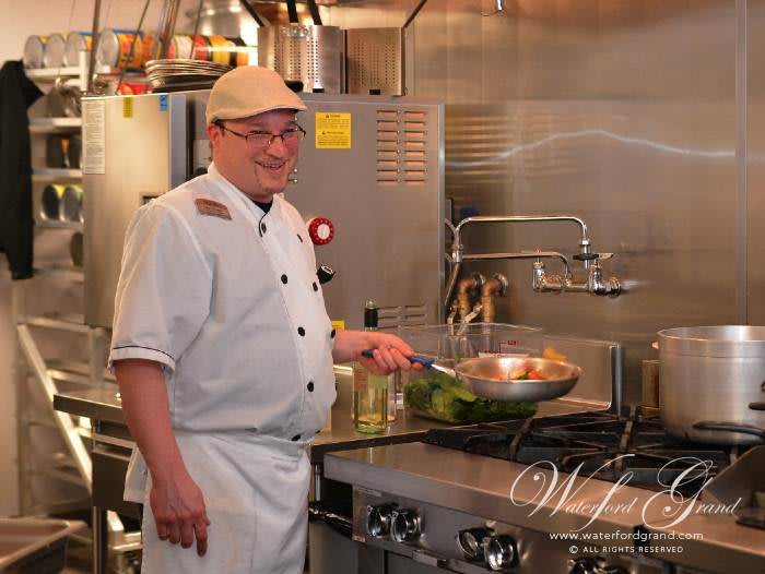 A chef cooking in a professional kitchen.