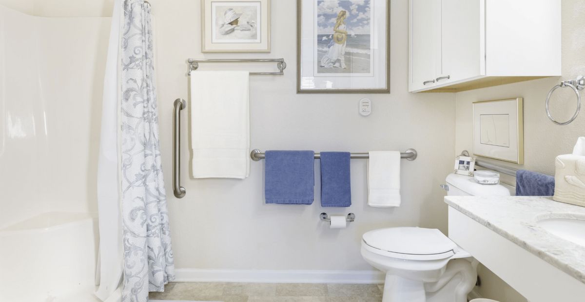 A clean bathroom with neatly arranged towels and decorative wall art.
