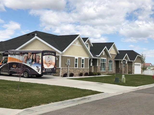 A suburban house with a vehicle parked in the driveway under a cloudy sky.