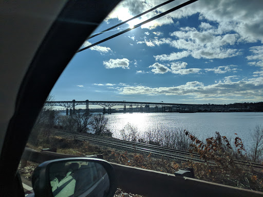 A picturesque view of a bridge over a shimmering river, framed by a clear blue sky.