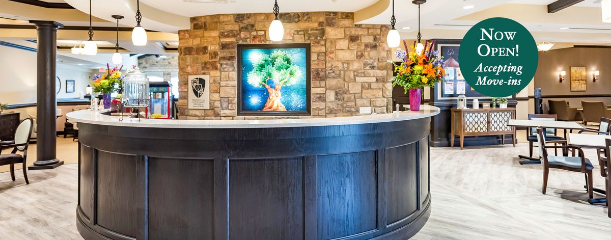 A stylish reception desk with artwork and flowers, set against a brick wall.