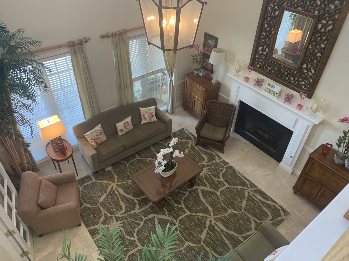 A well-decorated living room with cozy seating, a central coffee table, and a warm fireplace.
