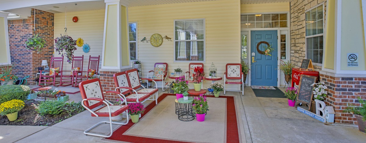 A cozy porch with comfortable seating, colorful plants, and decorative elements.