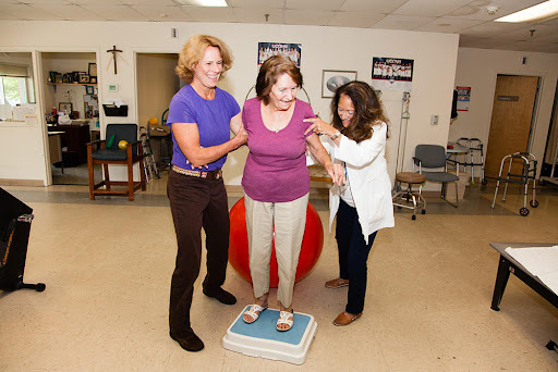 Healthcare professionals assist an individual during a balance training session.