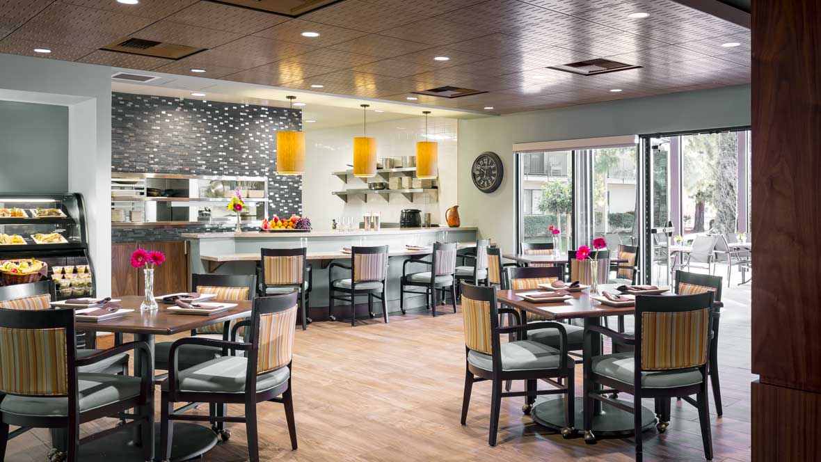 A modern restaurant dining area featuring stylish furnishings and a well-lit bar.