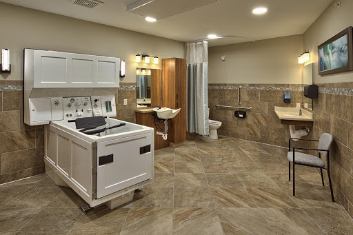 A modern bathroom featuring laundry facilities, complete with a toilet, sink, and shower.