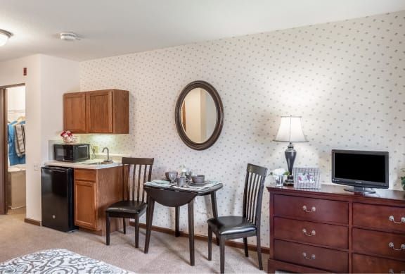Cozy apartment interior with a kitchenette, dining area, and classic furnishings.