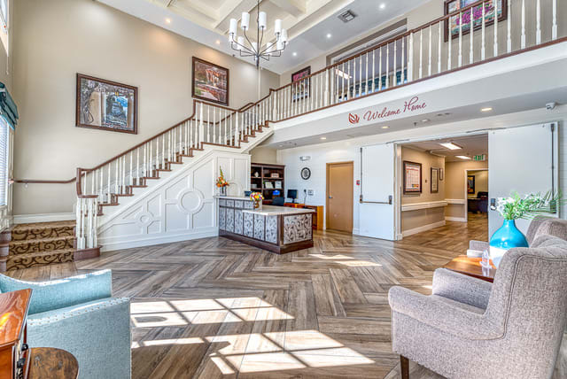 A spacious and elegant hotel lobby with a grand staircase and modern decor.