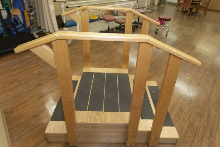 A wooden staircase bridge used in physical therapy and rehabilitation settings.