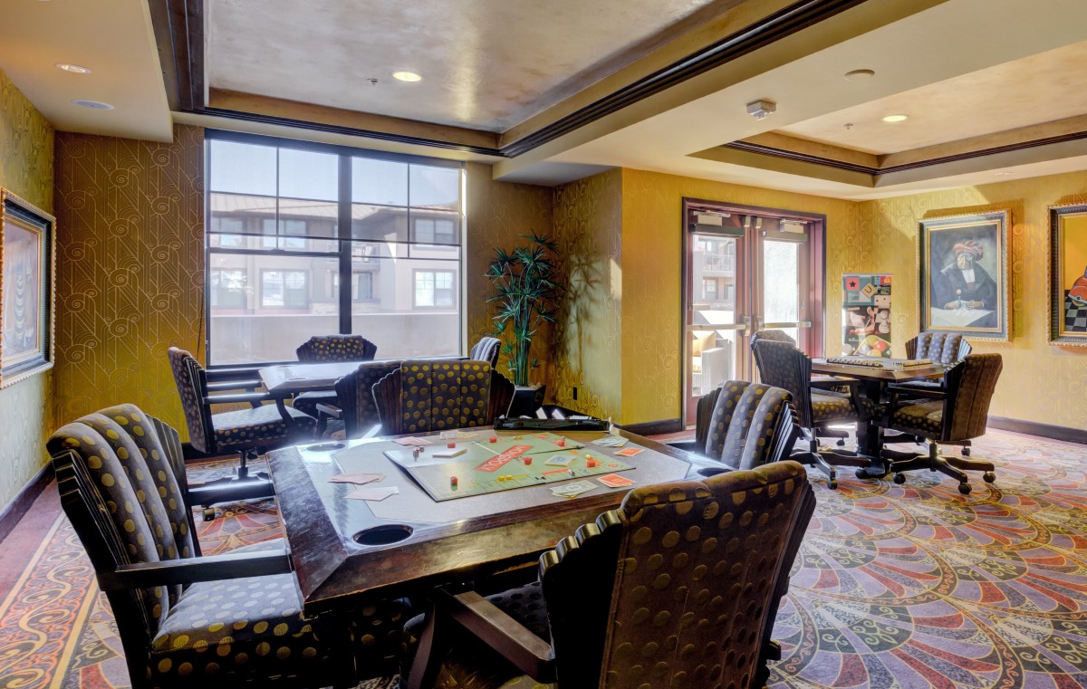 A cozy game room with a board game set up on the table and large windows providing natural light.