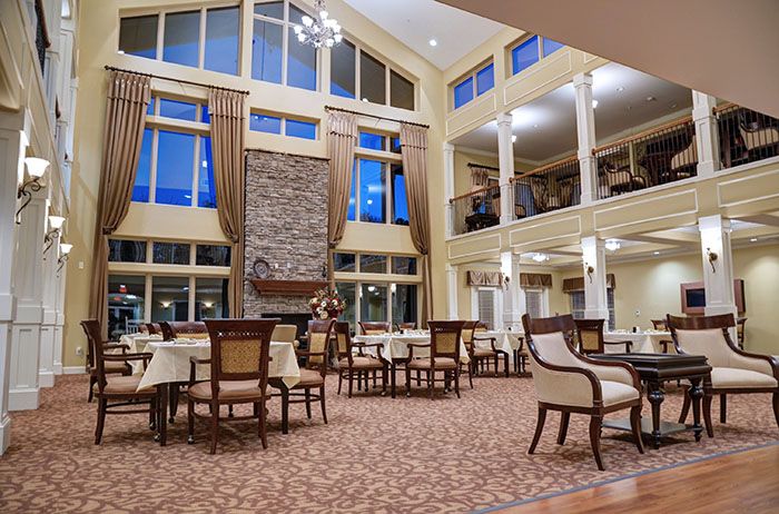 A spacious dining area with high ceilings, large windows, and elegant decor.