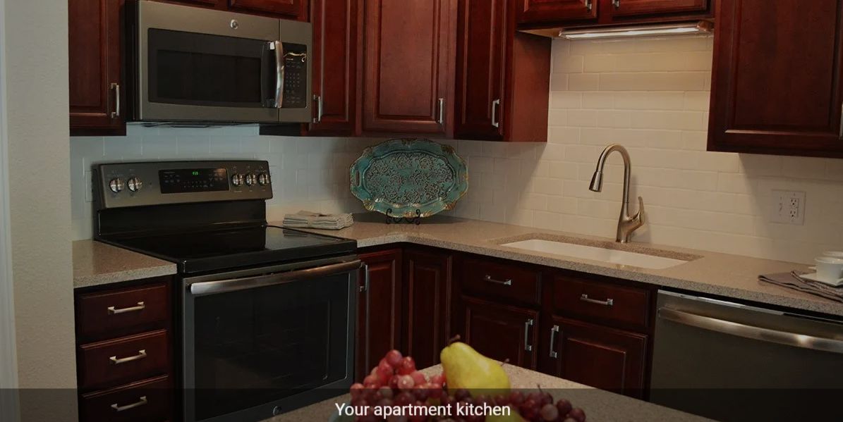 A cozy apartment kitchen with modern appliances and wooden cabinets.