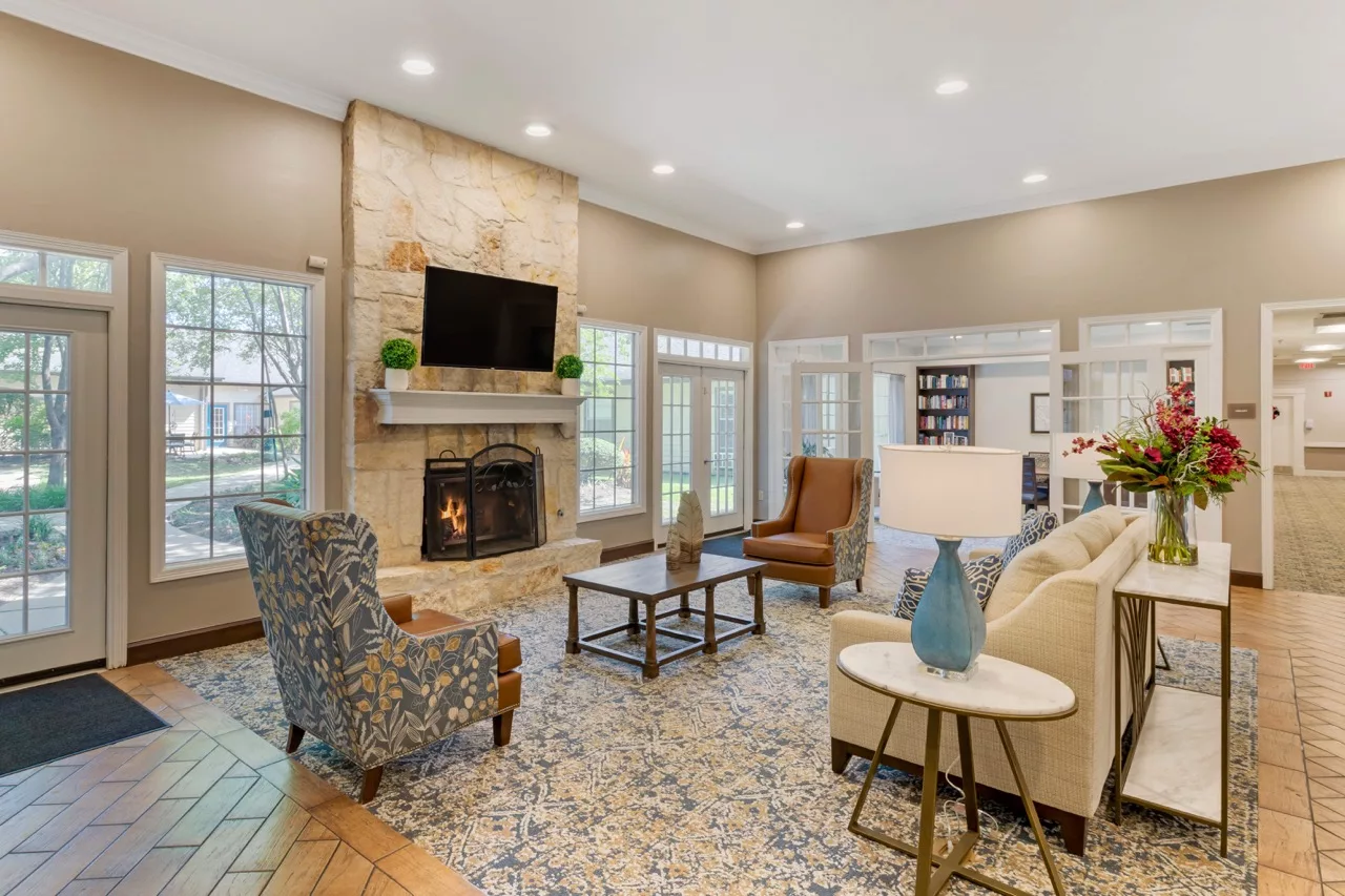 A modern and cozy living room with a fireplace, stylish furniture, and a mounted television.