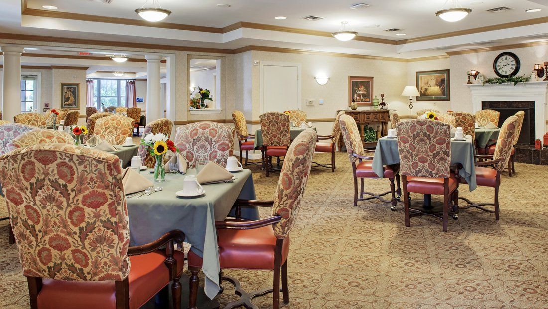 A well-decorated dining area with neatly arranged tables and chairs, featuring elegant decor and floral arrangements.