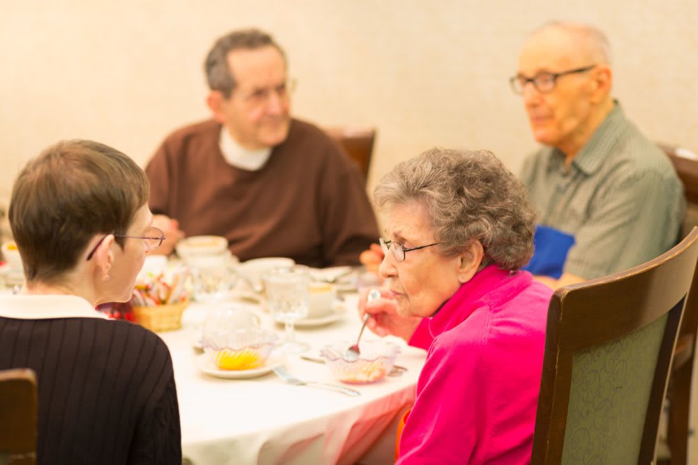A group of seniors enjoying a meal together at a dining table.