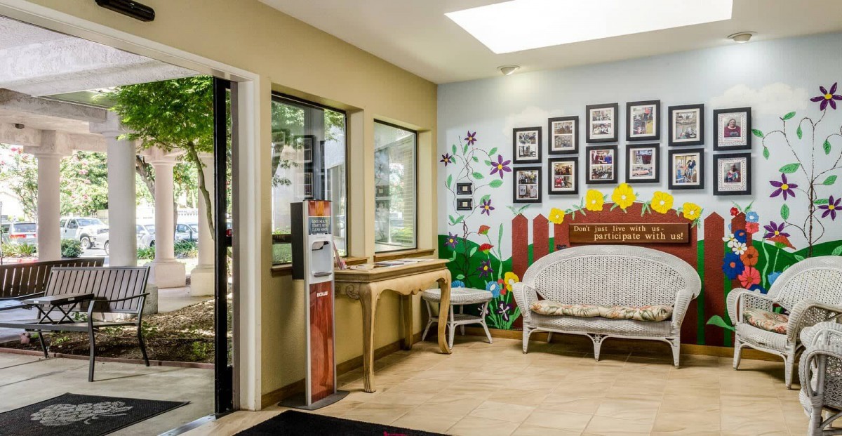 A cozy waiting room with a bench, decorated wall art, and natural light from large windows.