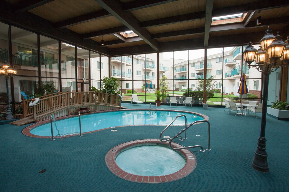 Indoor swimming pool and jacuzzi area in a resort setting.