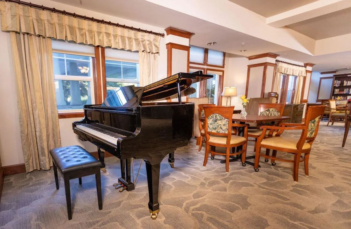 A cozy living room featuring a grand piano and elegant furniture.