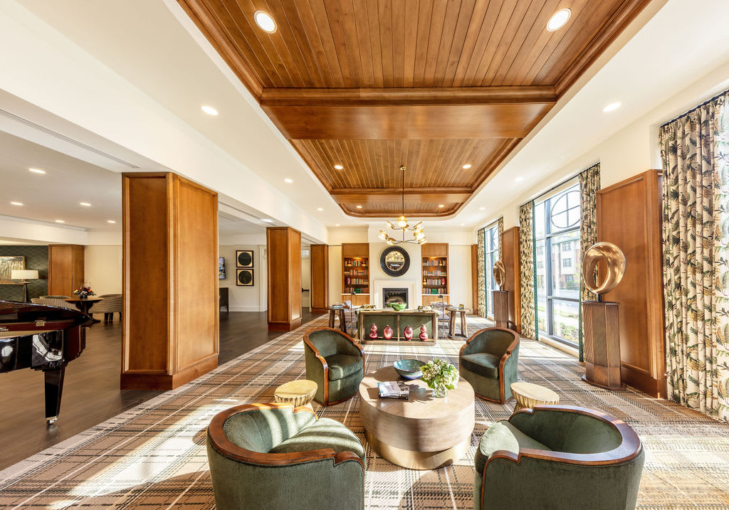 A luxurious living room with a wooden ceiling, modern furnishings, and ample natural light.