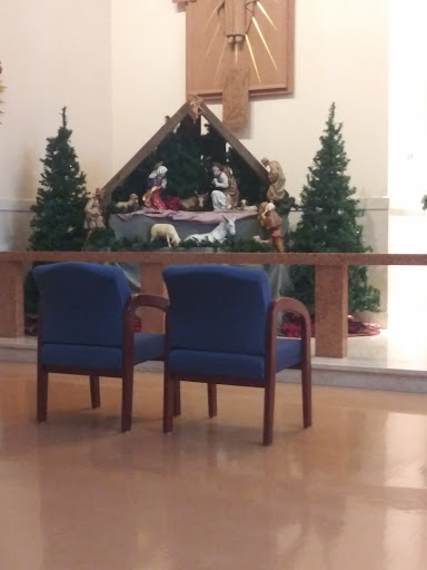 A cozy setting featuring two chairs in front of a Christmas nativity scene.