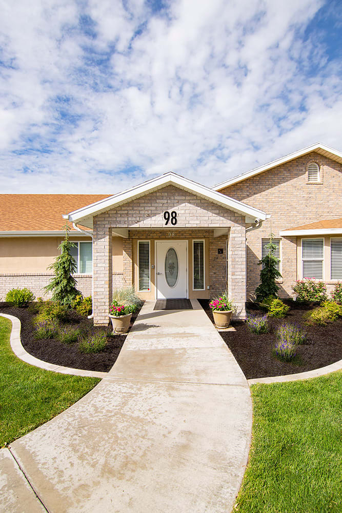 A residential house with a brick exterior and landscaped front yard.