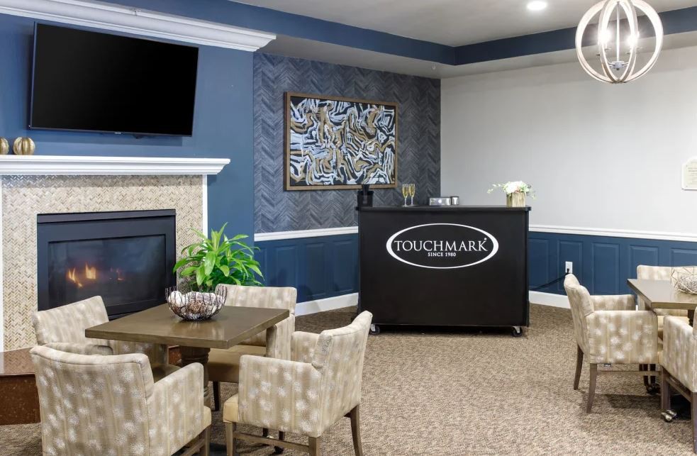 A modern living room interior featuring a seating area, fireplace, and decorative wall art.