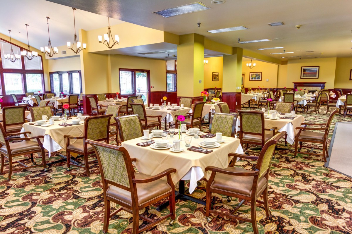 An elegantly arranged dining room with neatly set tables and chairs.