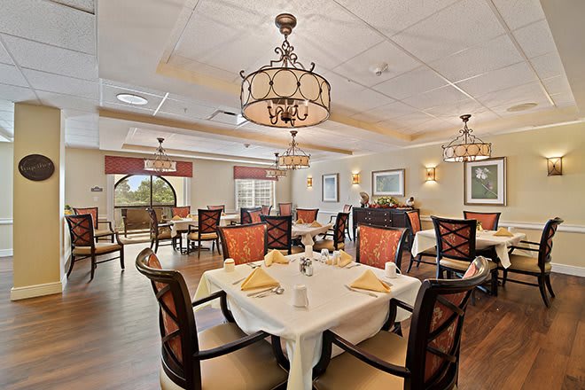 An elegant restaurant dining room with well-arranged tables and stylish chandeliers.