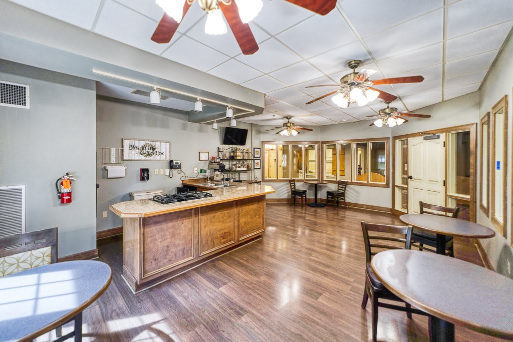 A well-lit office reception area with wooden flooring, featuring a counter and seating space.