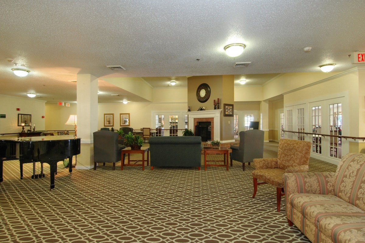 A spacious lobby with comfortable seating and a central fireplace.