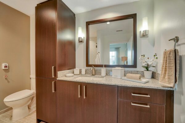 Modern bathroom with wooden cabinetry and a large mirror.