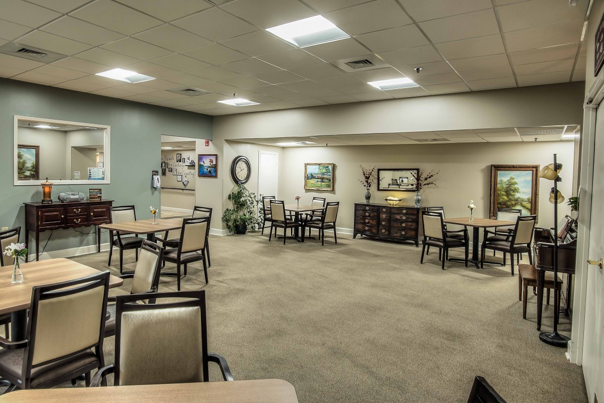 A spacious dining area with neatly arranged tables and chairs, featuring calming decor and ambient lighting.