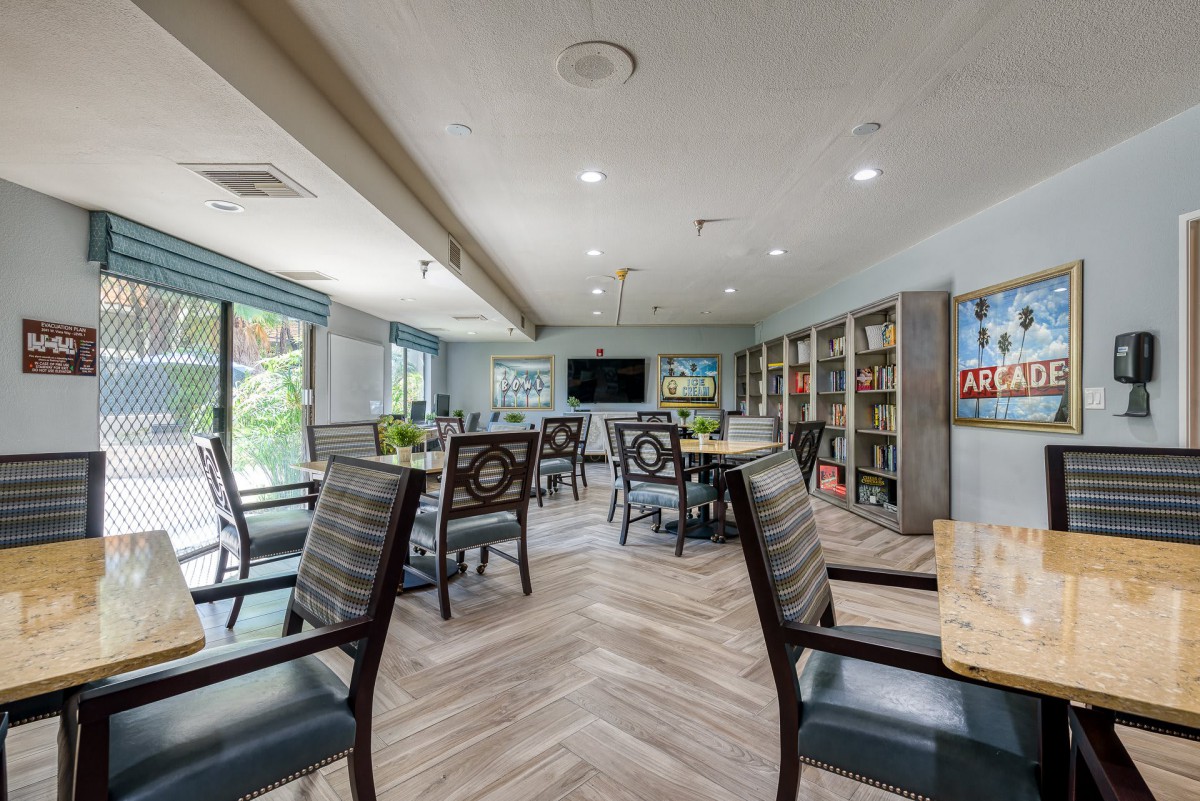 A cozy library with tables and chairs arranged for reading and study.