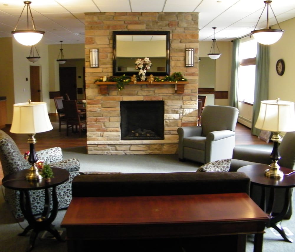 A cozy living room with a stone fireplace, comfortable seating, and elegant decor.