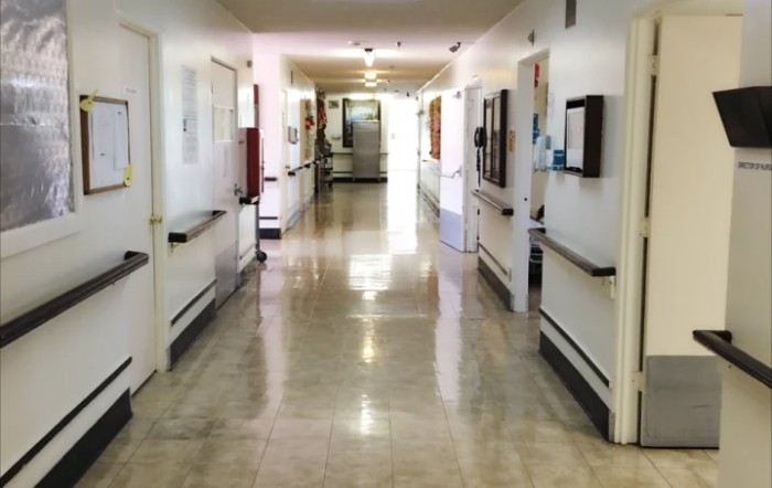 A clean and empty hospital corridor with bright lighting.