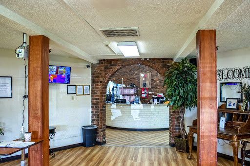 A cozy restaurant interior featuring a reception area with brick walls and wooden accents.