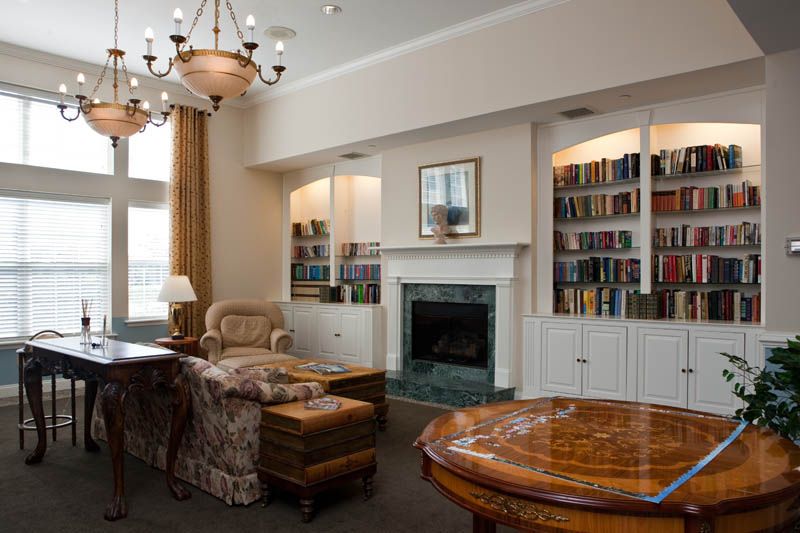 A cozy living room featuring a fireplace, bookshelves, and elegant furniture.
