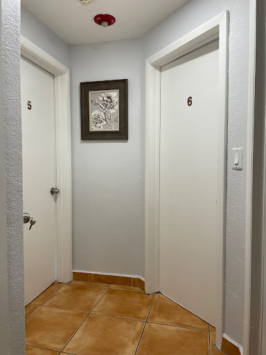 A glimpse of a hallway featuring two closed doors and a piece of artwork on the wall.