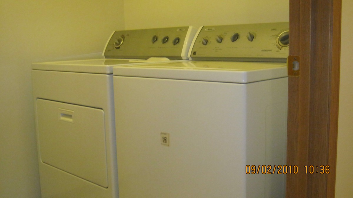 A washing machine and dryer set in a laundry room.