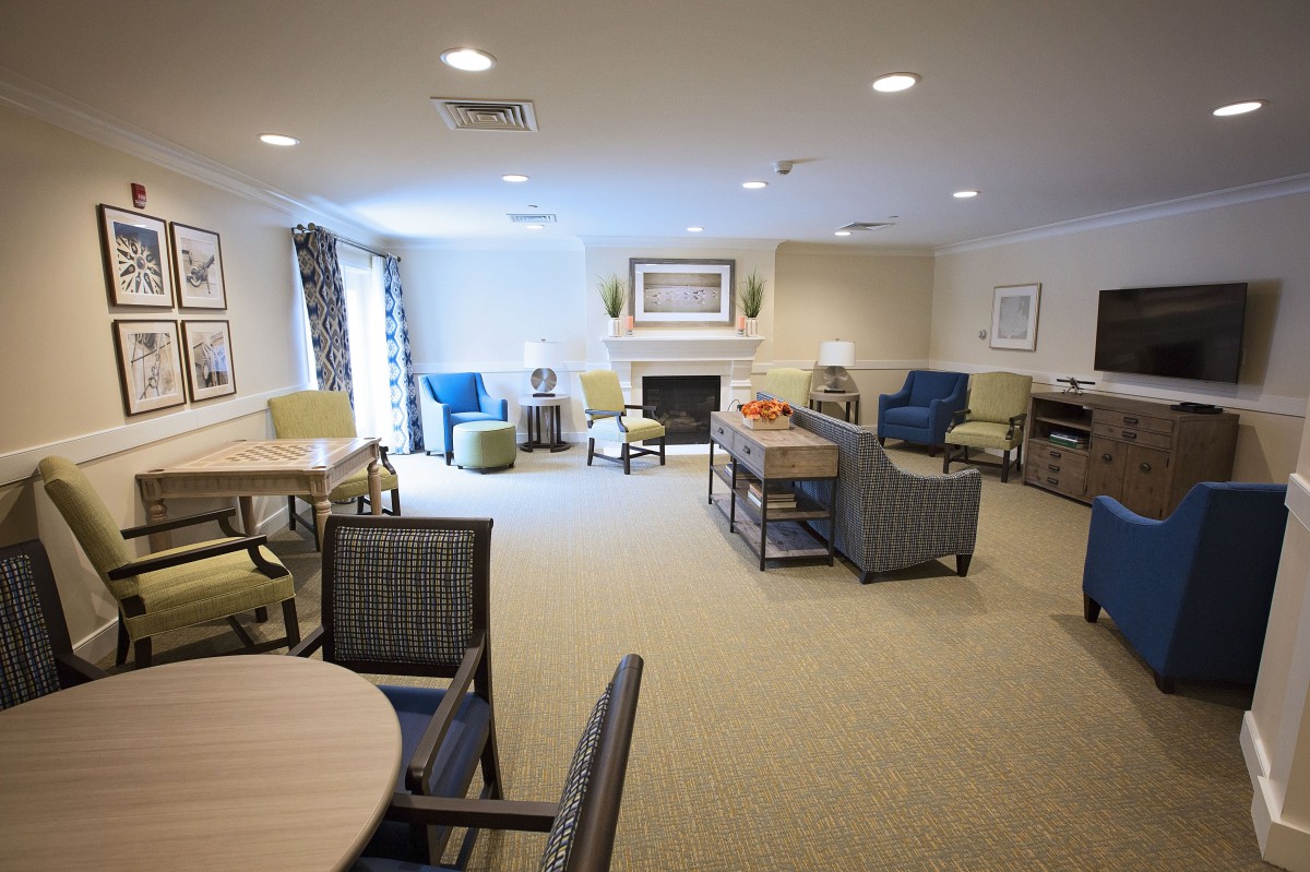 A well-furnished living room with multiple seating arrangements and a fireplace.