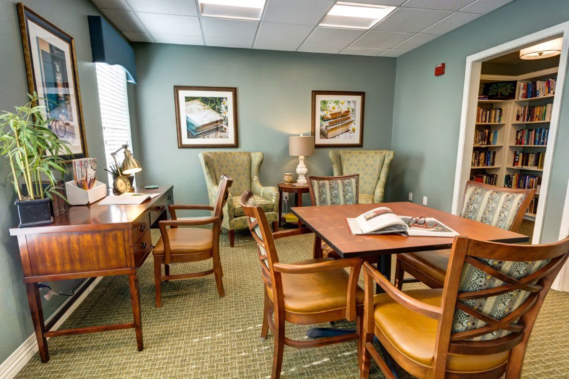 A cozy office waiting area with wooden furniture and decorative art on the walls.