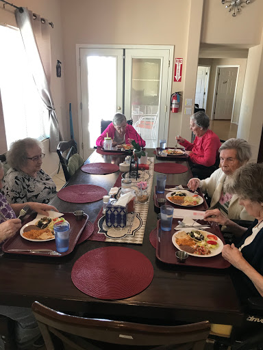 A group of elderly individuals enjoying a meal together around a dining table.