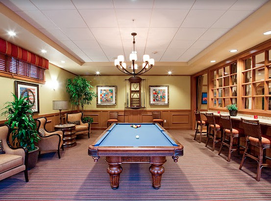 A stylish game room featuring a pool table and elegant wooden decor.